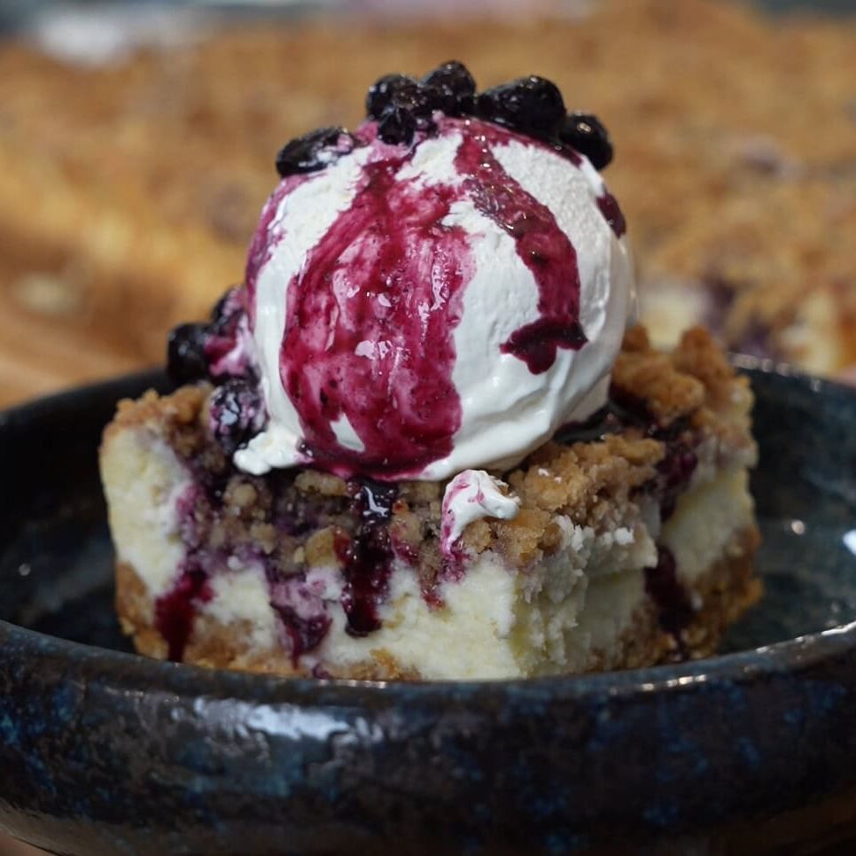 Blueberry crumble cheesecake bars with blueberry compote and whipped topping - Hungry Mockingbird